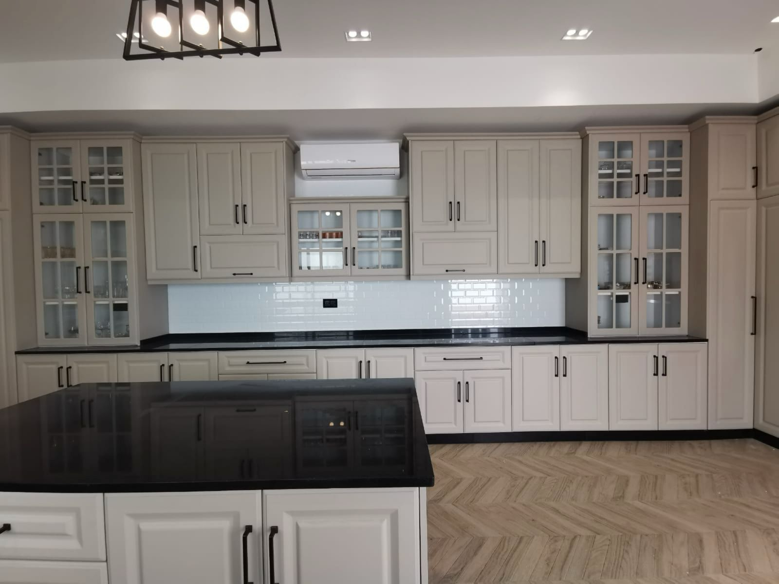 Large kitchen with glass-front cabinets and black granite countertops