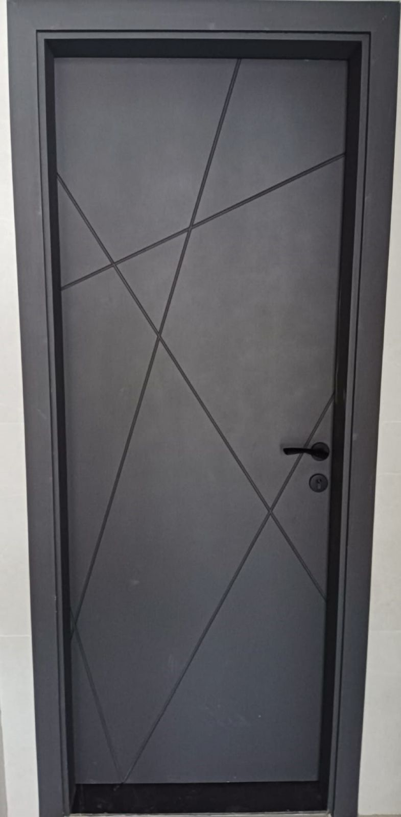 Installed dark door with geometric groove design